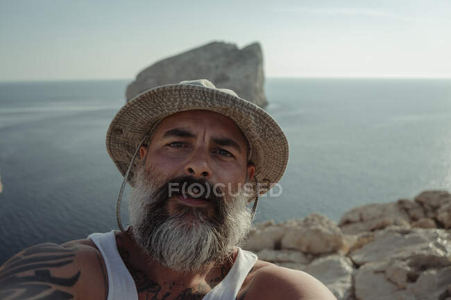 Hombre barbudo con sombrero tomando selfie con su cámara - foto de stock
