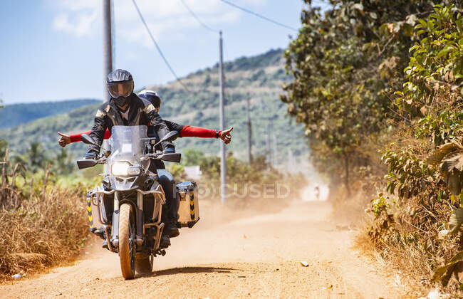 Two friends riding on their adventure motorbike on dirt road — Stock Photo