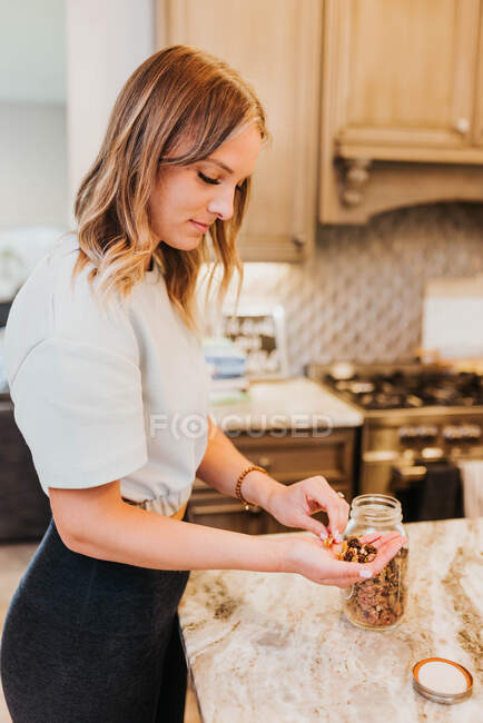 Mujer joven haciendo un pastel en la cocina - foto de stock