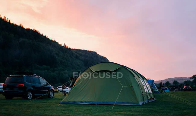 Tent at the sunset with a camp camping in the mountains. — Stock Photo