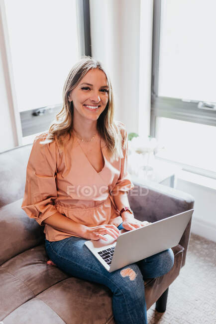 Красива молода жінка використовує ноутбук вдома — стокове фото