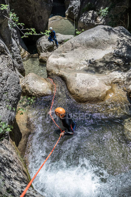 Wide angle view of two girls, one rappelling and the other waiting in — Stock Photo