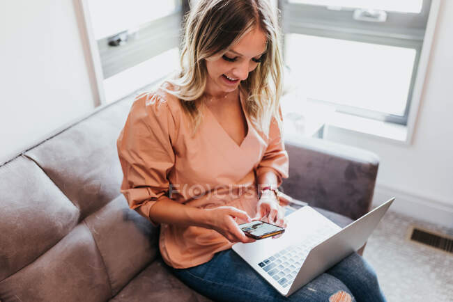 Bela jovem com cartão de crédito e laptop em casa — Fotografia de Stock