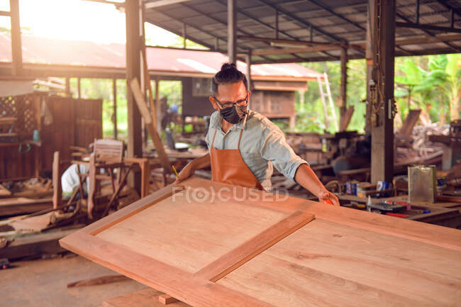 Man doing woodwork in carpentry. Carpenter work on wood plank in workshop,vintage style — Stock Photo