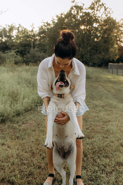 Jeune femme avec son chien en été — Photo de stock