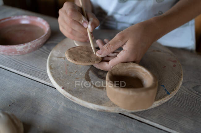 Крупним планом дитячі руки, що формують глиняний посуд — стокове фото