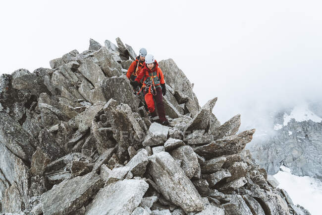 Due scalatori che scendono salendo sui pinnacoli nelle giornate nuvolose — Foto stock