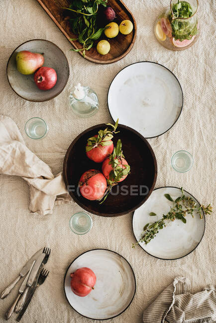 Fall table styling concept. Flat-lay of dinnerware with fresh seasonal fruits, drink in jug, dried flowers and glasses over beige linen tablecloth, top view. Preparing for Thanksgiving day — Stock Photo