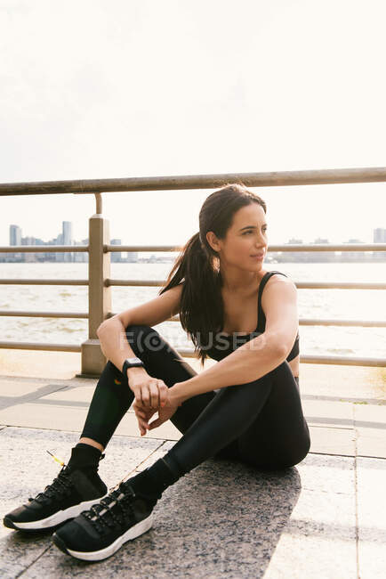 Jeune femme en forme se détendre après avoir fait du jogging en plein air — Photo de stock