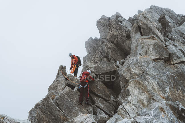 Dos escaladores descendiendo cresta expuesta en el día helado - foto de stock