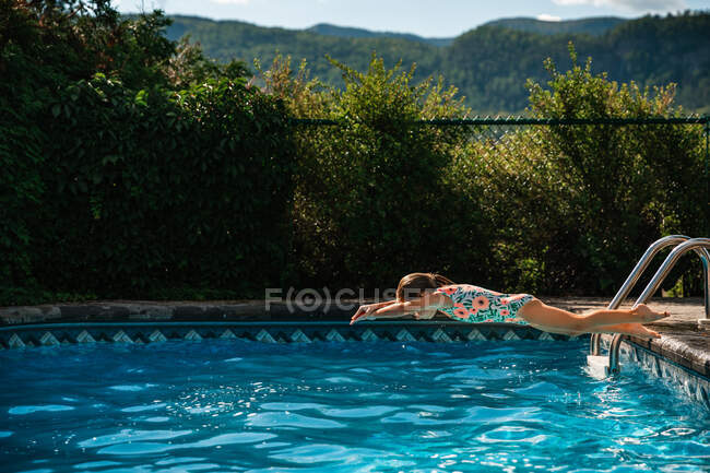 Menina de 5 anos tentando mergulhar em uma piscina durante o verão — Fotografia de Stock