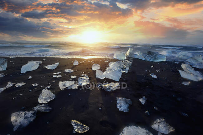 Schöner Sonnenuntergang über dem berühmten Diamond Beach, Eisscholle am schwarzen isländischen Sandstrand. Jokursarlon, Diamond Beach, Island — Stockfoto