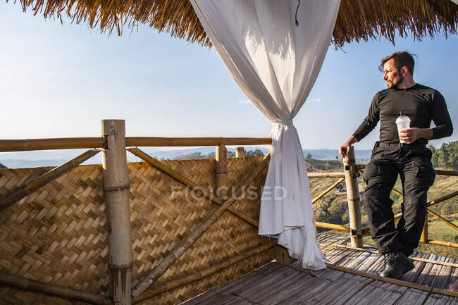 Homem desfrutando da vista de uma cabana de bambu no norte da Tailândia — Fotografia de Stock