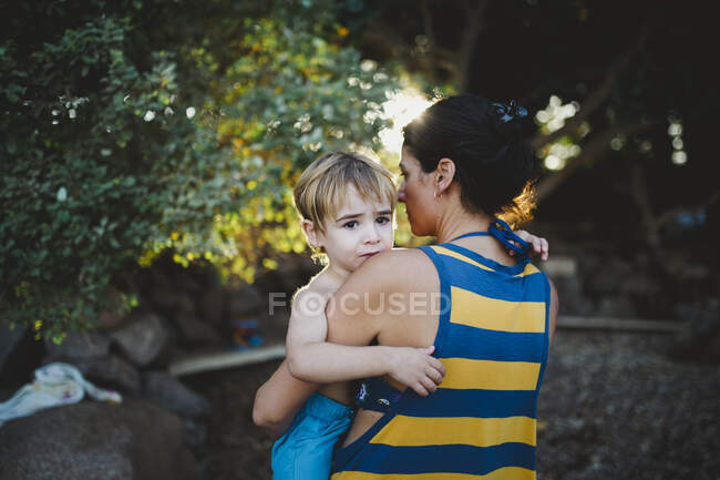 Mother carrying her son on the beach — Stock Photo