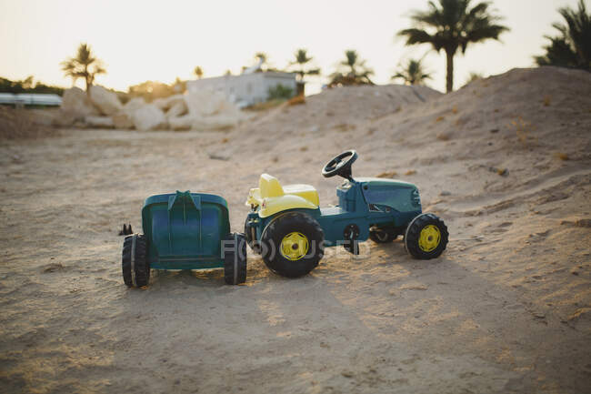 Tractor de juguete infantil en un patio vacío - foto de stock