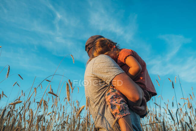 Pai brincando com sua filhinha fofa no campo. — Fotografia de Stock