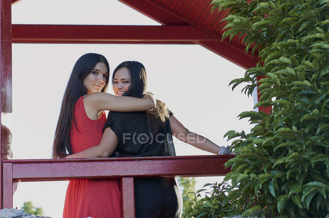 Молодая лесбийская пара улыбается и смотрит друг на друга в парке — стоковое фото