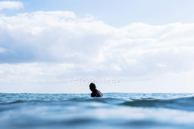 Серфер чекає хвилі, сидить на борту, синій — стокове фото