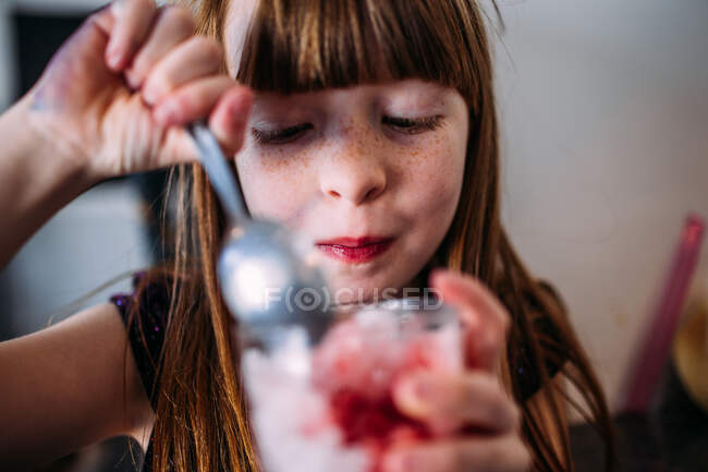 Porträt eines jungen Mädchens, das einen Schneehügel im Inneren isst — Stockfoto