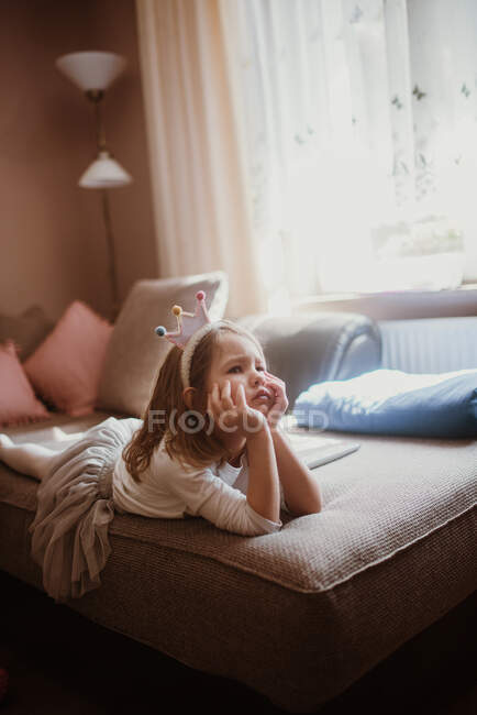 Wütendes kleines Mädchen im Kostüm liegt auf dem Bett. — Stockfoto