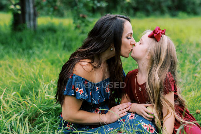 A mother and daughter giving each other a kiss — Stock Photo