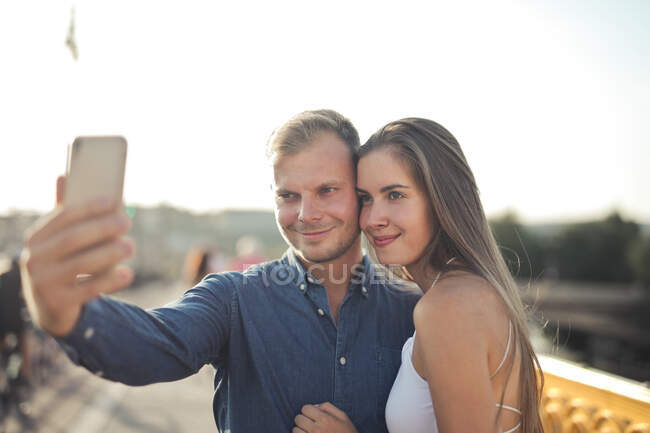 Jovem mulher leva uma selfie na rua — Fotografia de Stock