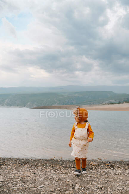 Petite fille s'amuser sur la plage de sable — Photo de stock