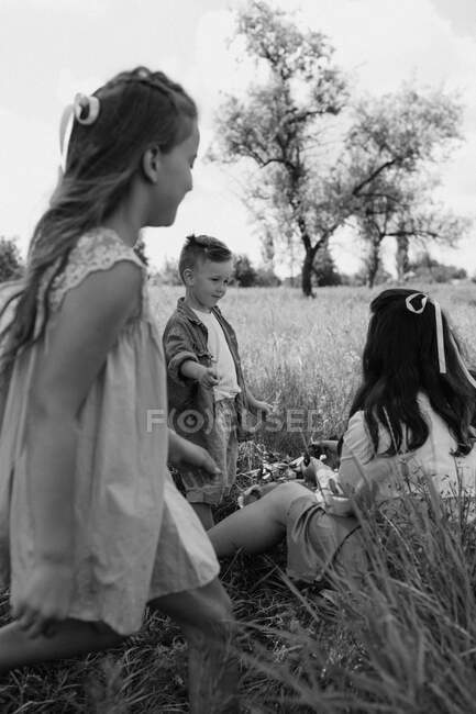 Familia en la hierba. Foto en blanco y negro - foto de stock