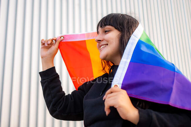 Portrait d'une femme latina portant le drapeau arc-en-ciel — Photo de stock