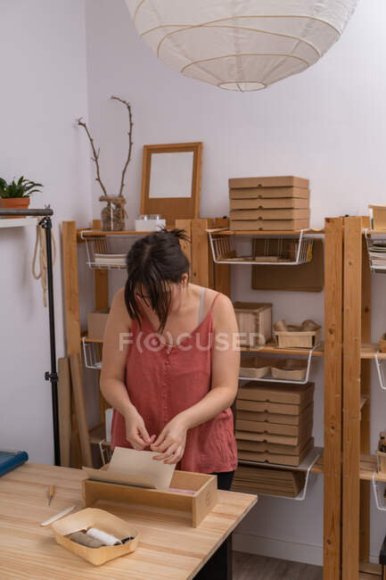 Giovane artigiana che lavora nel suo laboratorio di prodotti biologici — Foto stock