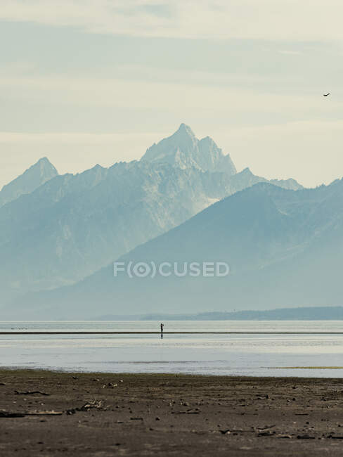 Man on lake with mountains in Grand Teton National Park in Wyoming — Stock Photo