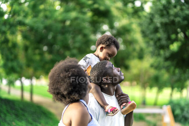 Отец со своей маленькой дочерью на плечах во время прогулки — стоковое фото