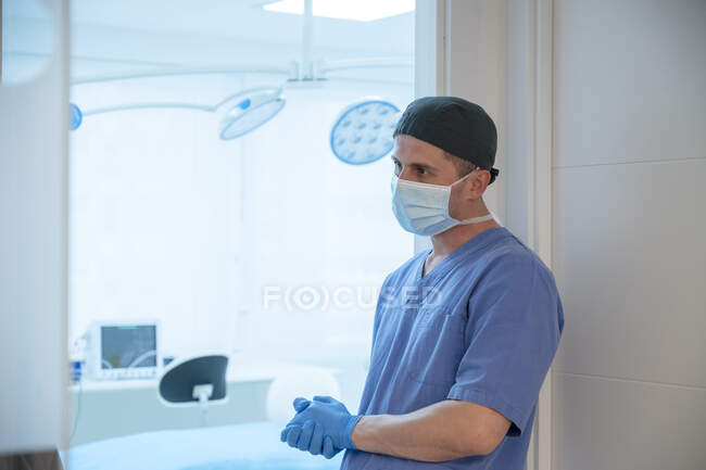 Мужской хирург перед началом операции в операционной — стоковое фото
