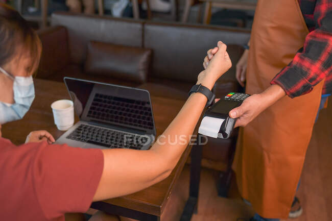 Cliente fazendo pagamento sem fio ou sem contato usando smartwatch — Fotografia de Stock