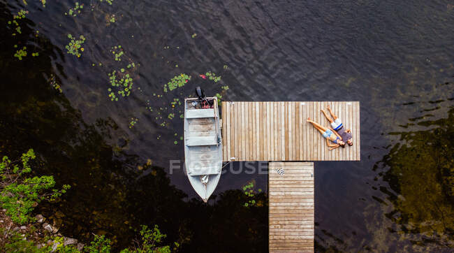 Overhead aerial image of couple laying on a dock together. — Stock Photo