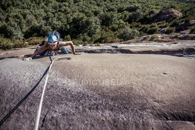 Mujer escalando roca pared losa en España - foto de stock