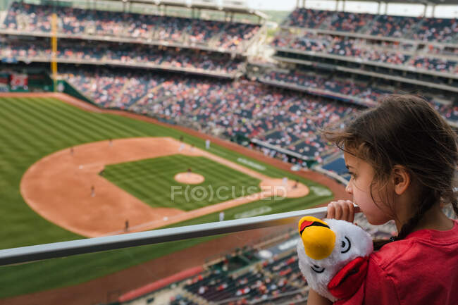 Kleines Mädchen beobachtet Baseball-Spiel von der Tribüne — Stockfoto