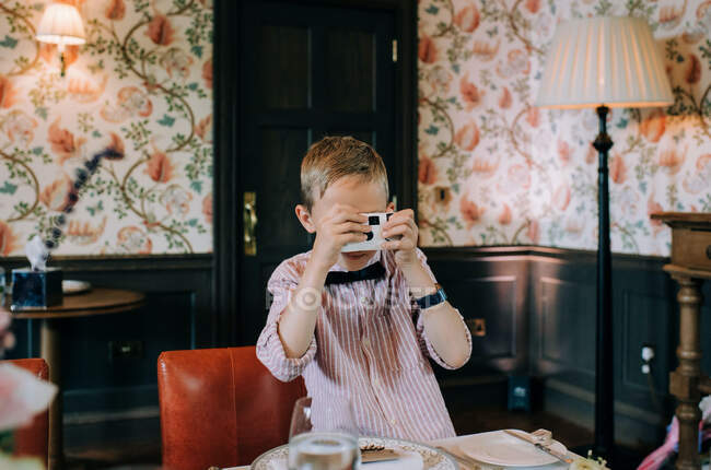 Boy taking pictures with disposable camera at a wedding — Stock Photo