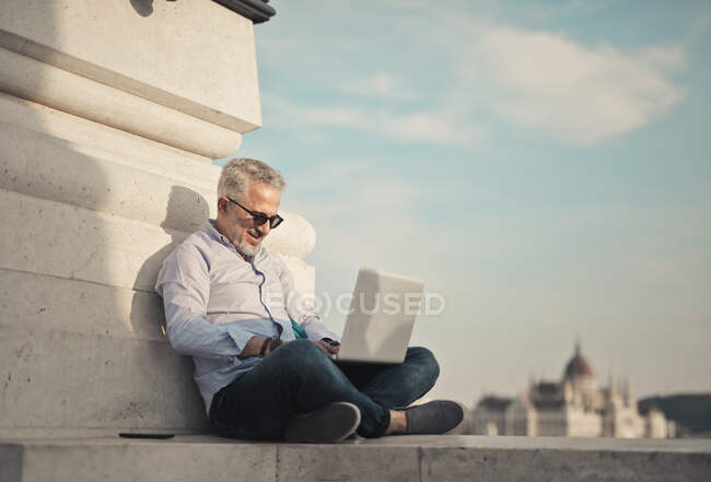 Uomo lavora al computer su un ponte in budapest — Foto stock