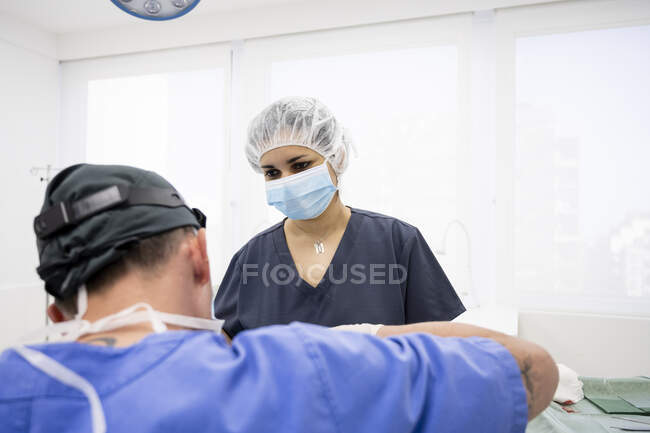 Chirurgiens pratiquant une chirurgie de la paupière à un patient anonyme — Photo de stock
