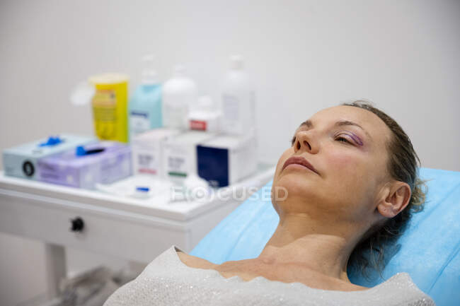 Brunette woman resting on the bed after visit her in hospital indoor — Stock Photo
