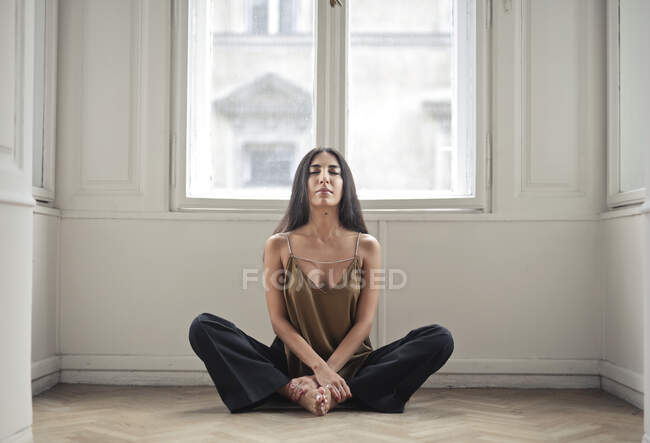 Молодая женщина практикует йогу дома — стоковое фото