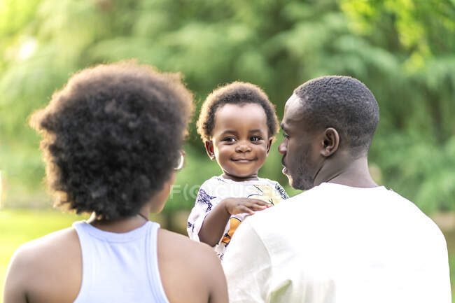 African couple walking with their daughter in the park — Stock Photo