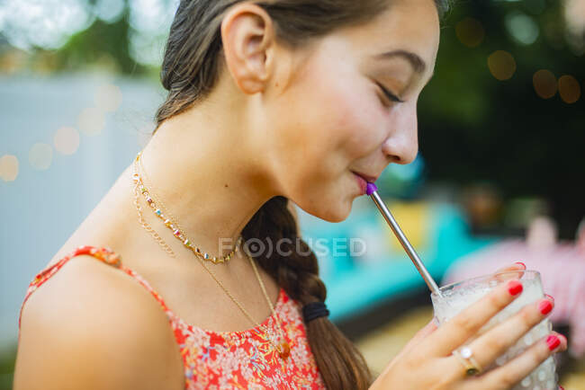 Ritratto del cortile di una ragazza che beve un frullato — Foto stock