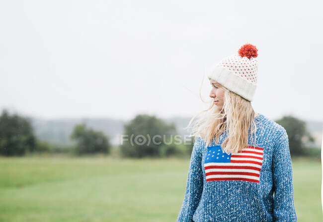 Schönes junges Mädchen mit weißem Hut und roter Mütze, draußen im Hintergrund, auf dem Land — Stockfoto