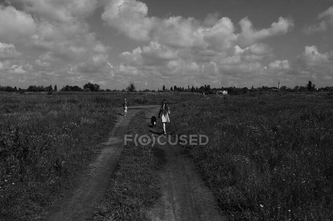 Strada rurale lungo la quale corrono i bambini — Foto stock