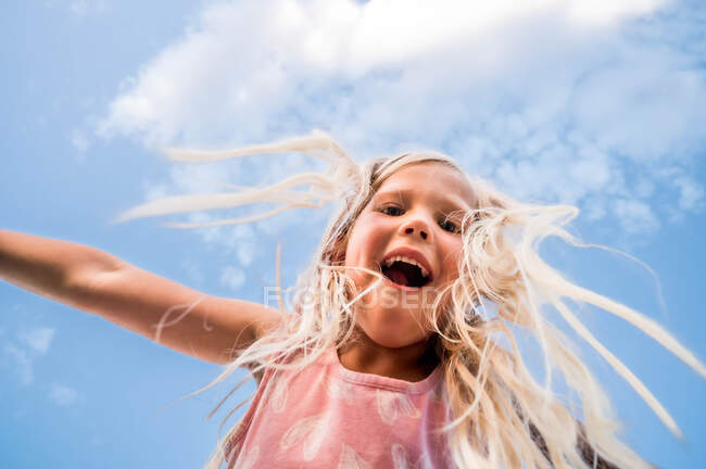 Menina loira olhando para baixo com um fundo azul céu — Fotografia de Stock