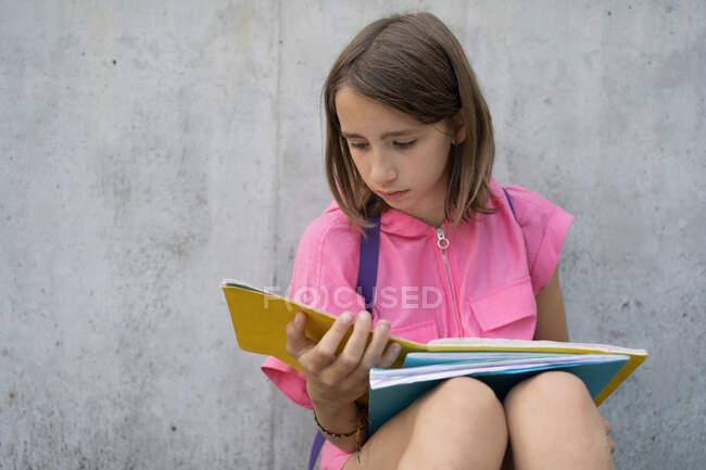 Девочка-подросток делает домашнюю работу на улице — стоковое фото