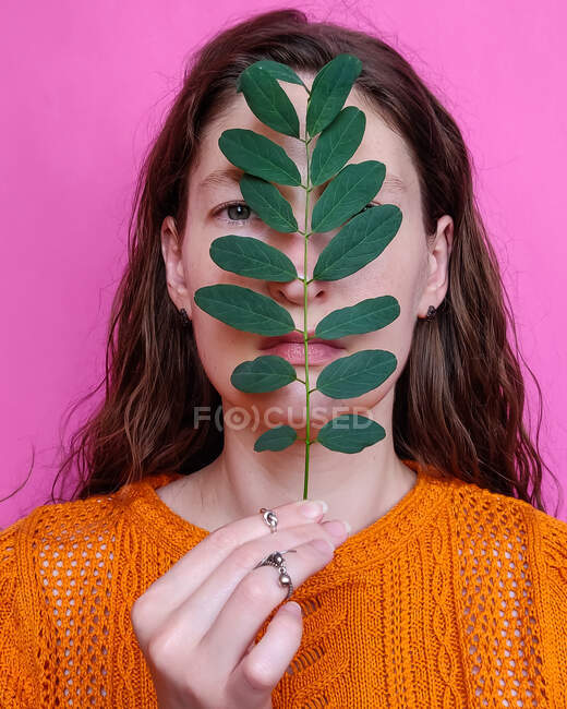Porträt einer Frau auf rosa Hintergrund mit einem Zweig — Stockfoto