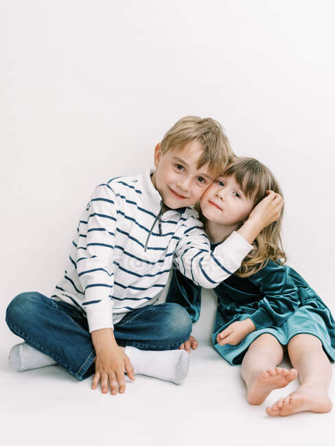 Brother and Sister posing on an off-white background — Stock Photo